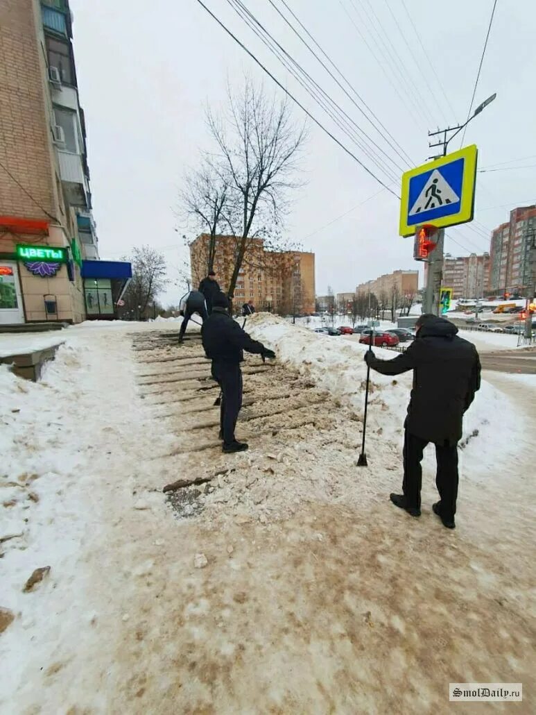 Обработка улиц реагентами. Посыпание песком лестниц на улице. Люди идут по улице зима Смоленск. Все кто выйдет на улицу погибнет