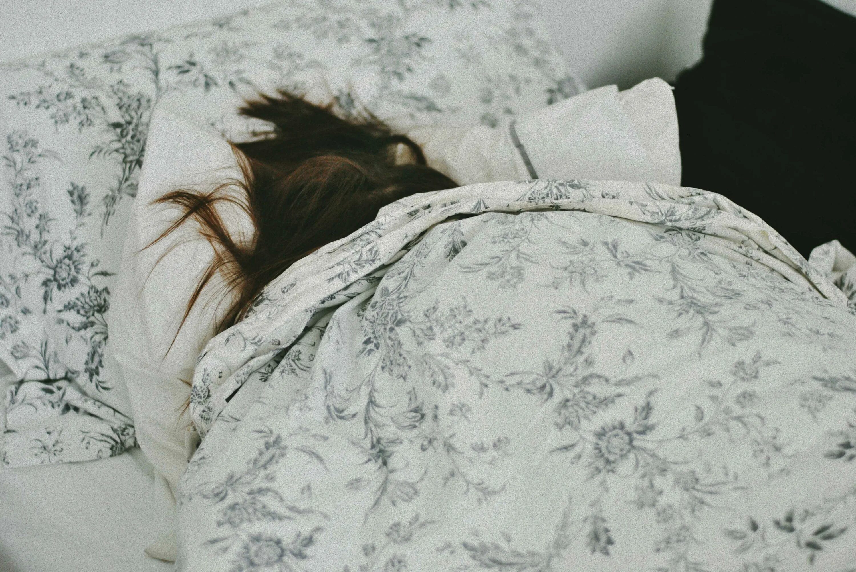 Просто лежит на кровати. Девочка в кровати под одеялом.