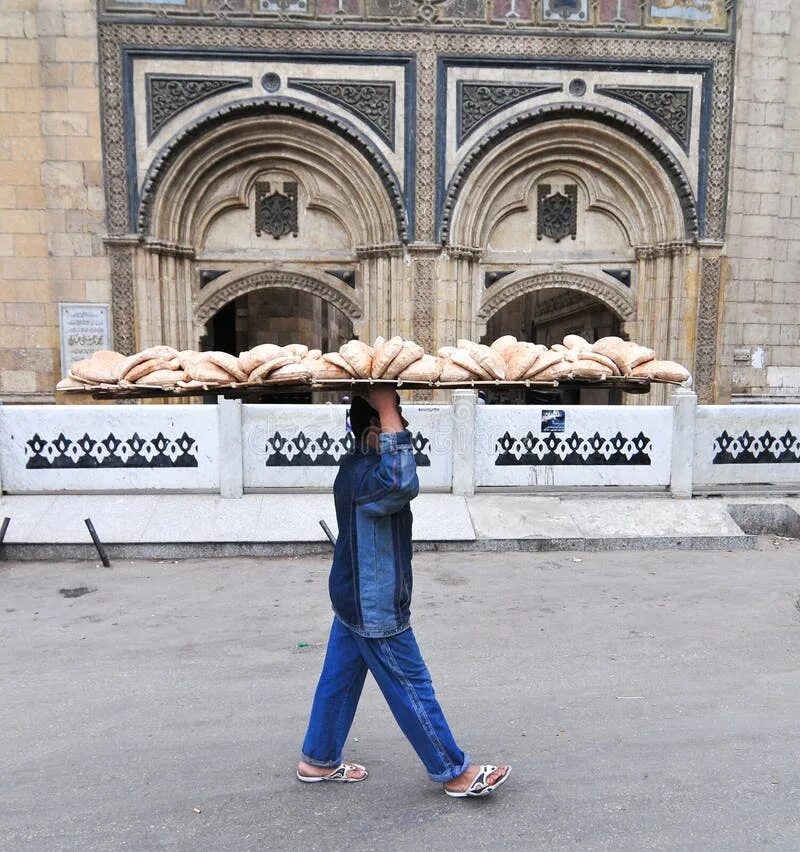 Человек идет за хлебом. Доставщик хлеба Каир. Доставщики хлеба в Египте. Подача хлеба в Египте. Каир хлеб на голове.