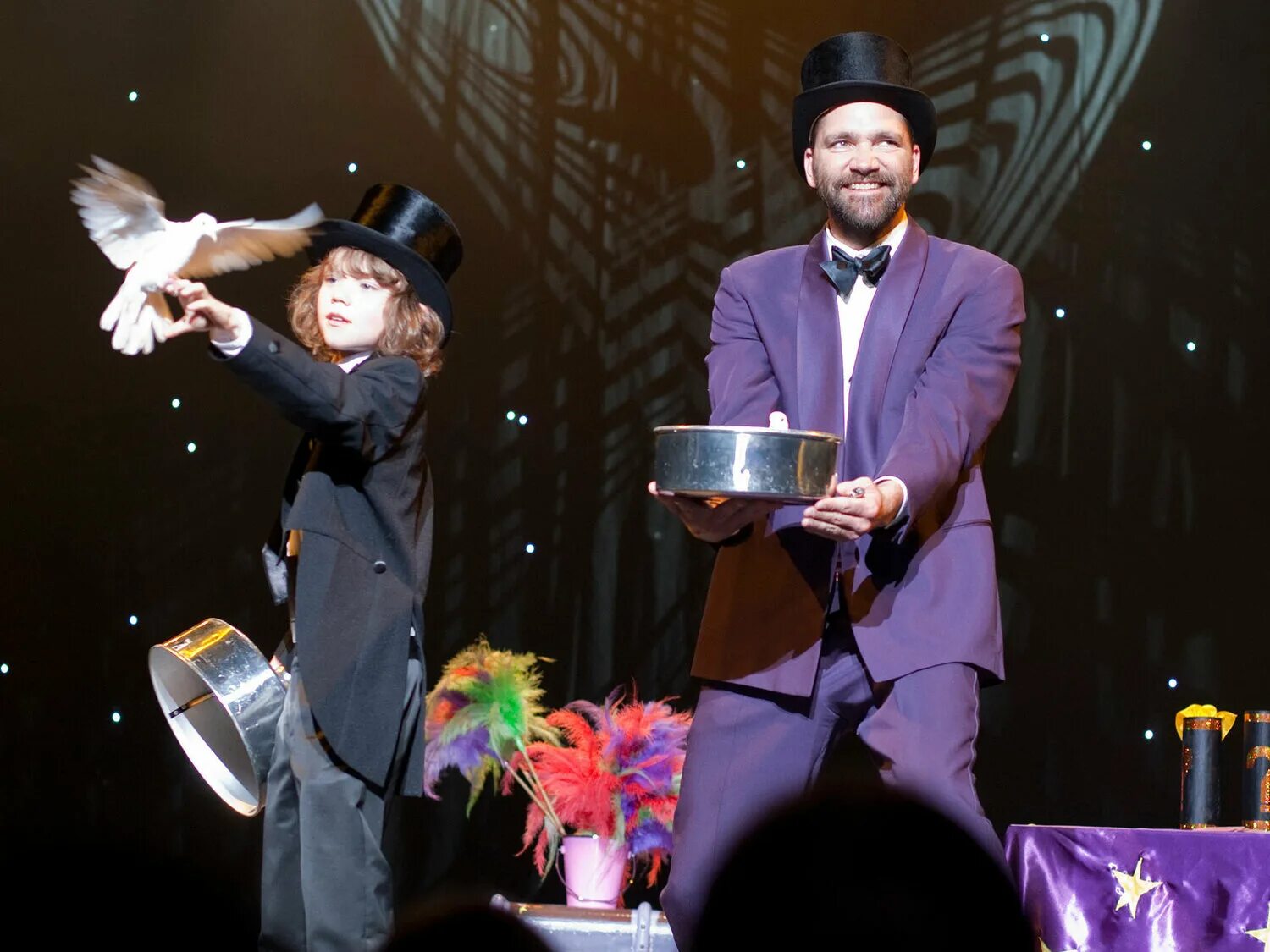 фокусник на сцене. фокусник волшебник иллюзионист. фокусник микромаг. иллюзионист в цирке. иллюзионист в цирке.