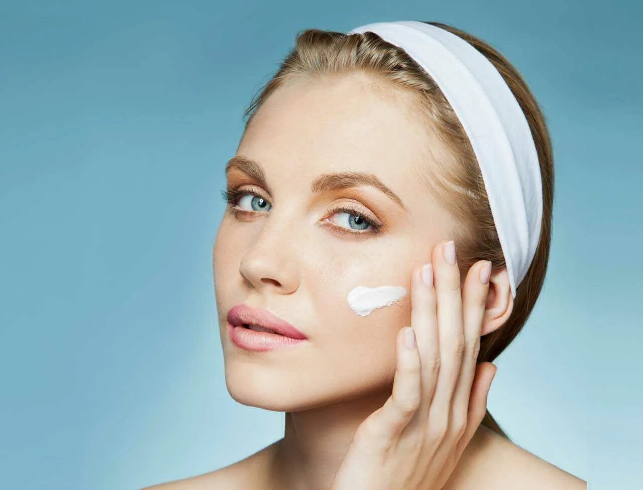 Нанесение крема на лицо. Девушка наносит крем на лицо. Девушка с кремом. Девушка наносит крем. Помазать лицо.