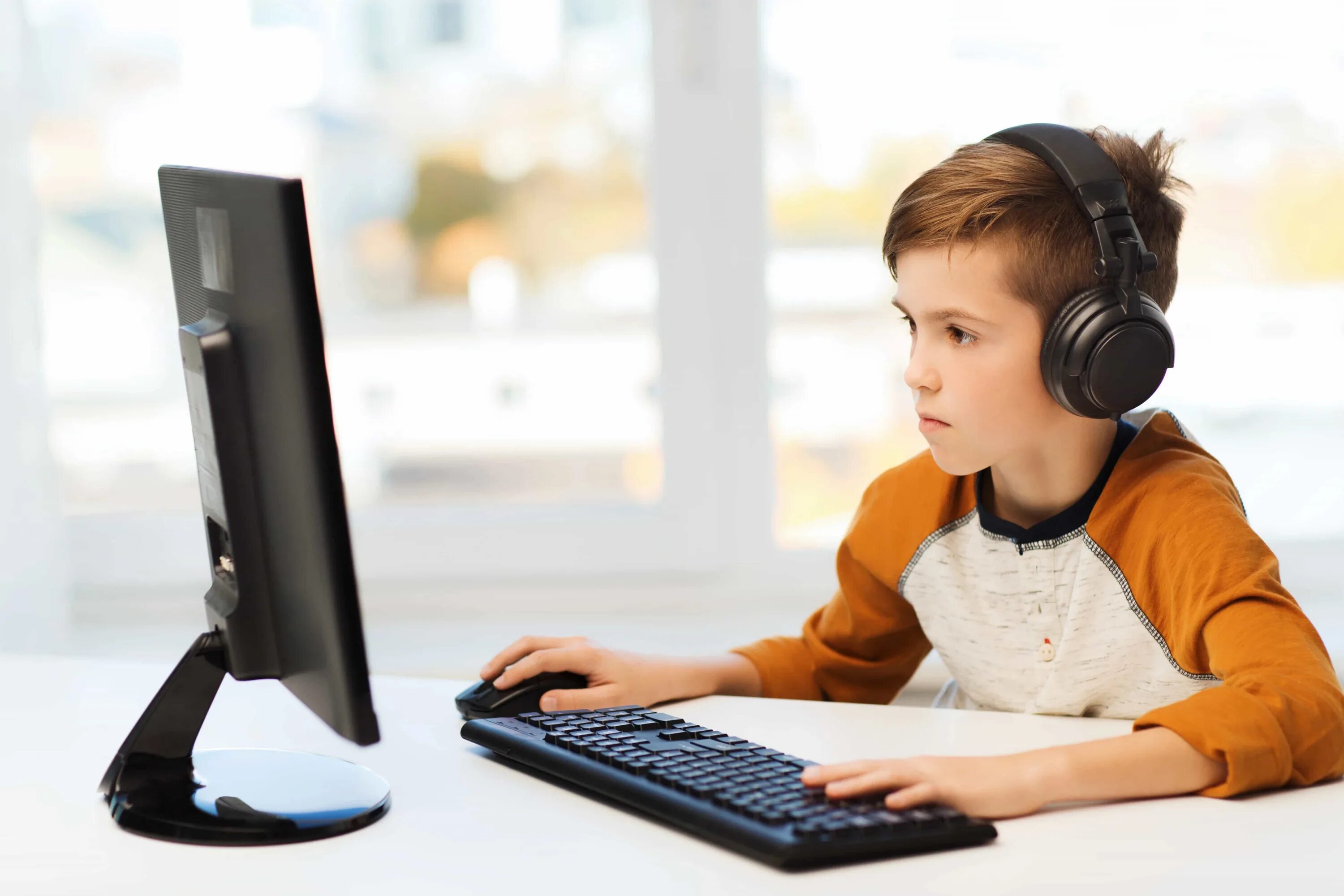 Компьютер для детей. Мальчик с компьютером. Мальчик с наушниками за а компьютера. Школьники на информатике.