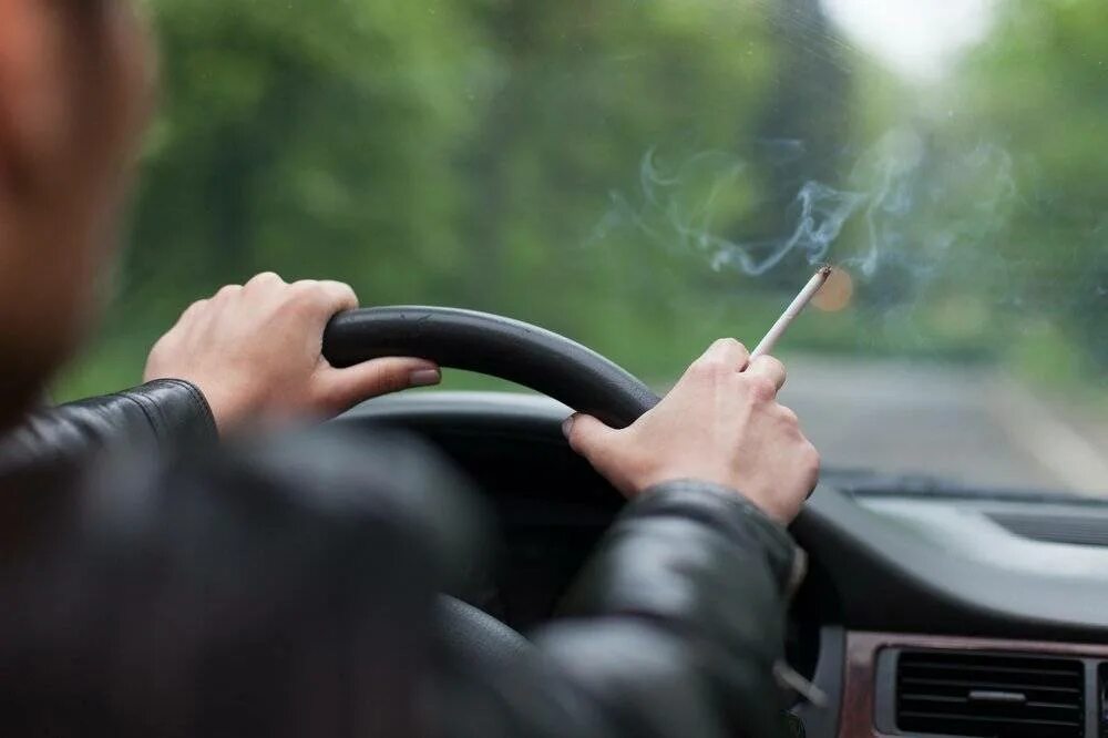 Курит за рулем. Курение в автомобиле. Курит в салоне автомобиля. Парень курит в машине. Можно курить в такси