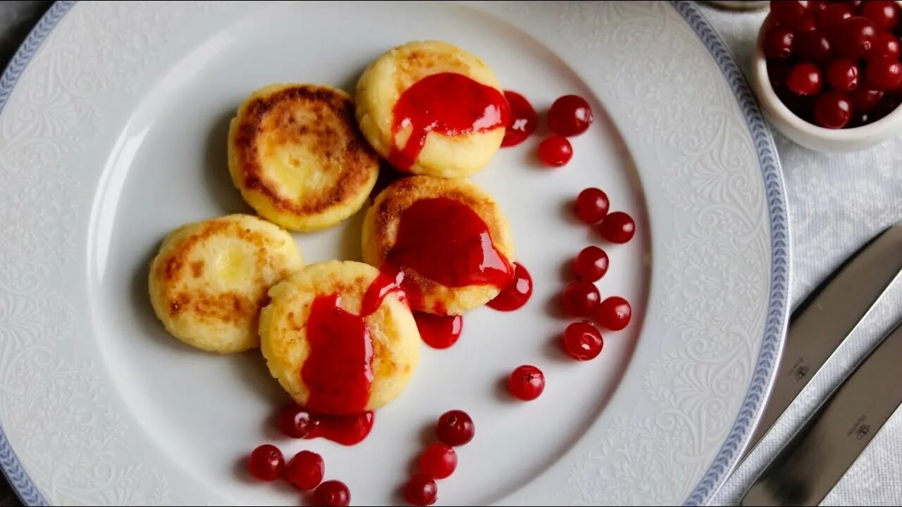 Сырники чье. Сырники с клюквой. сырники из творога с клюквенным соусом. сырники творожные с клюквой. сырники с клюквенным соусом технология приготовления.