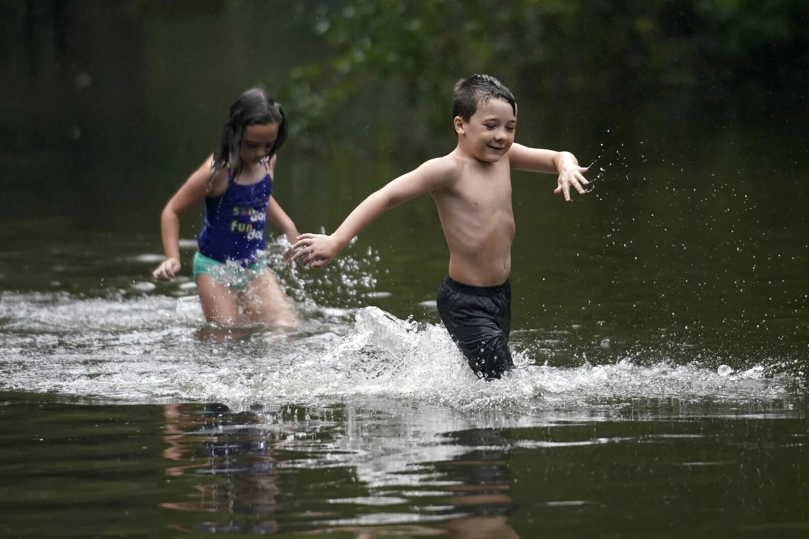 Силен вода. Вода бежит. Девочка бежит к воде при наводнении. Сильная вода. По пояс в воде.