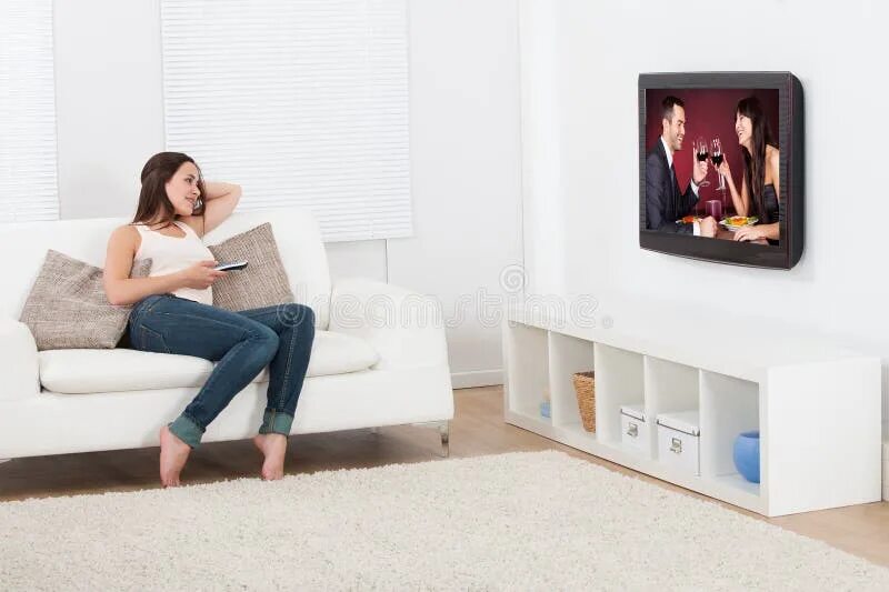 Женщина смотрит телевизор.