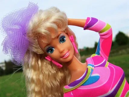 a barbie doll with long blonde hair and blue eyes wearing a pink dress in a...