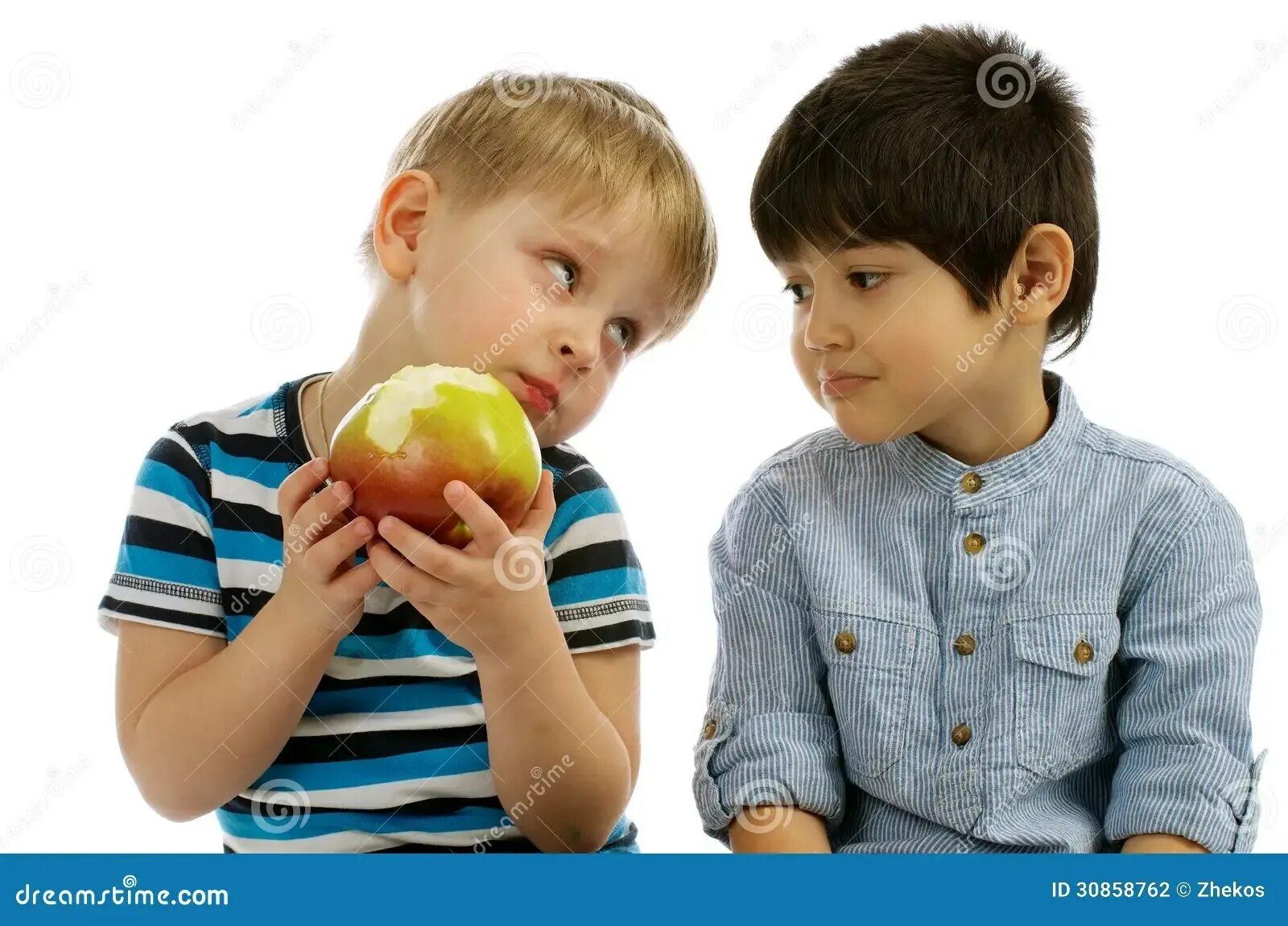 Ребенок делится с другом. Дети делятся друг с другом. Ребенок делится яблоком. Мальчик делится яблоком.