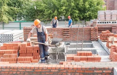 Два каменщик укладывают плиткой