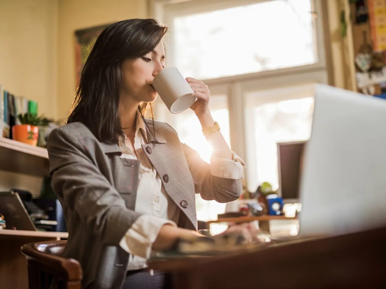 Женщина принимает на дому. Девушка пьет кофе. Женщина кофе пьет на работе. Пьет кофе на работе. Занятая женщина.