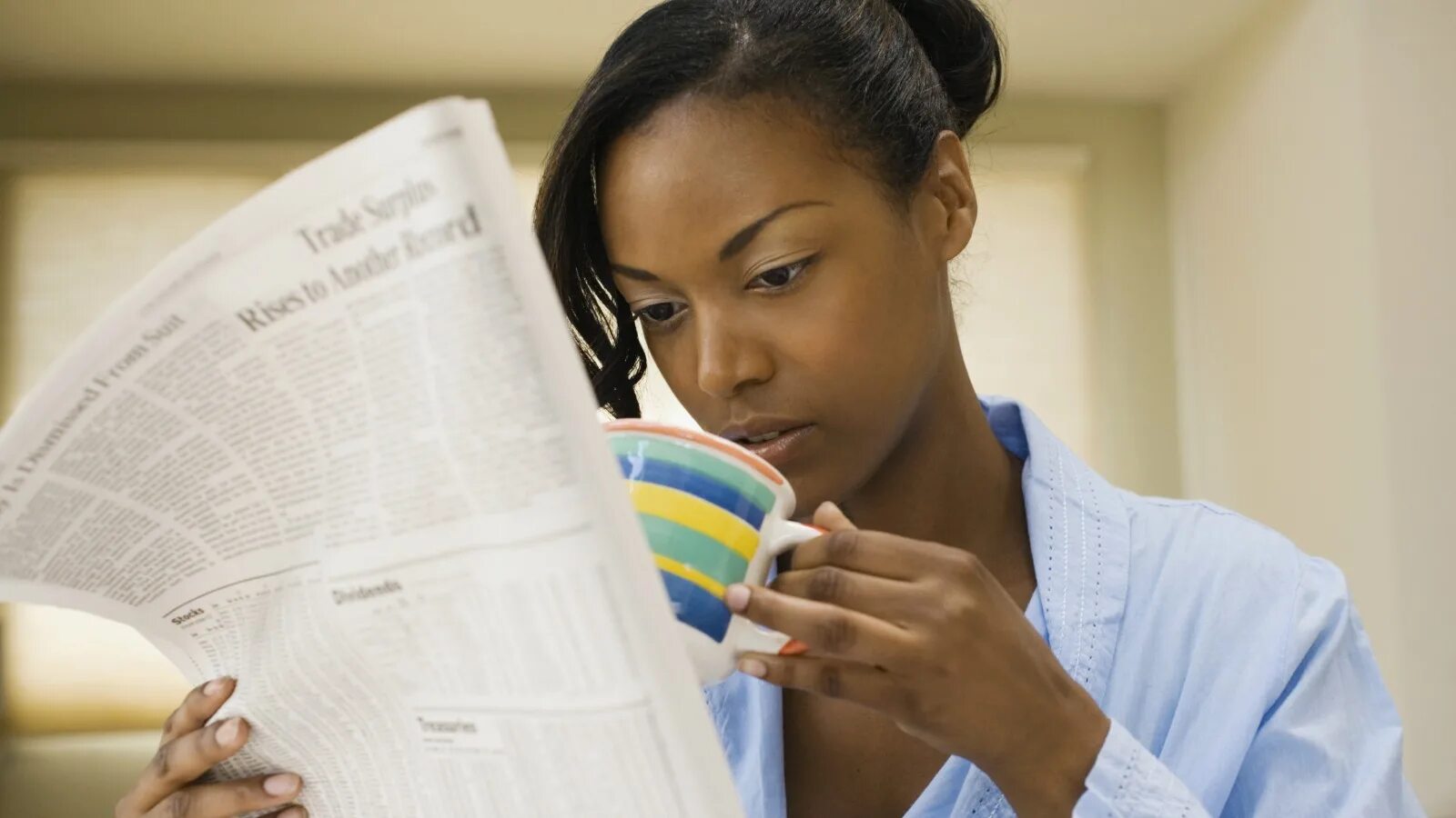 Black reader. Person is reading newspaper. black person with a paper. she is reading. speak a paper.
