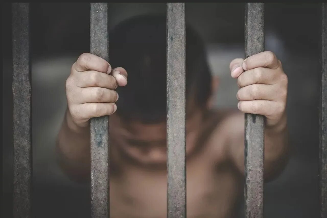 Преступник за решеткой. Сел за решетку сын. Тюремная решетка. Заключение в тюрьму. Преступник за решеткой.