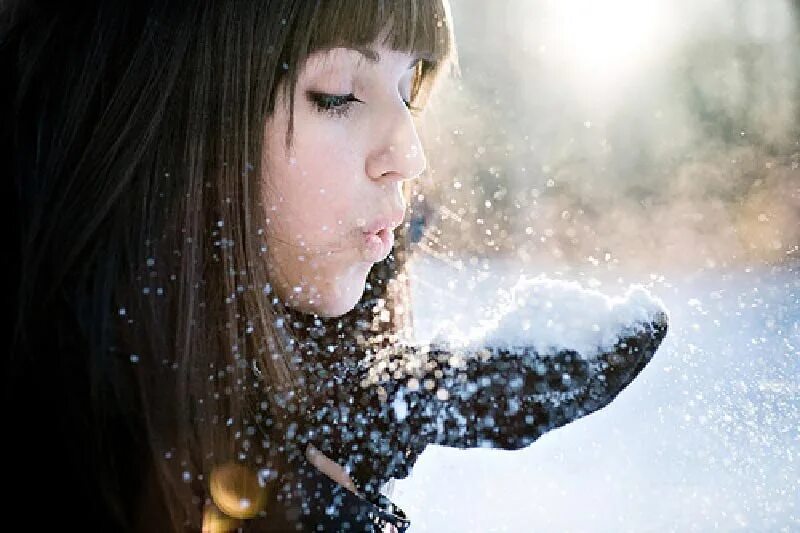 Тают руки тают губы. Девушка дует на снег. Девушка сдувает снег с ладоней. Девушка сдувает снежинки. Девушка сдувает снежинки с ладоней.