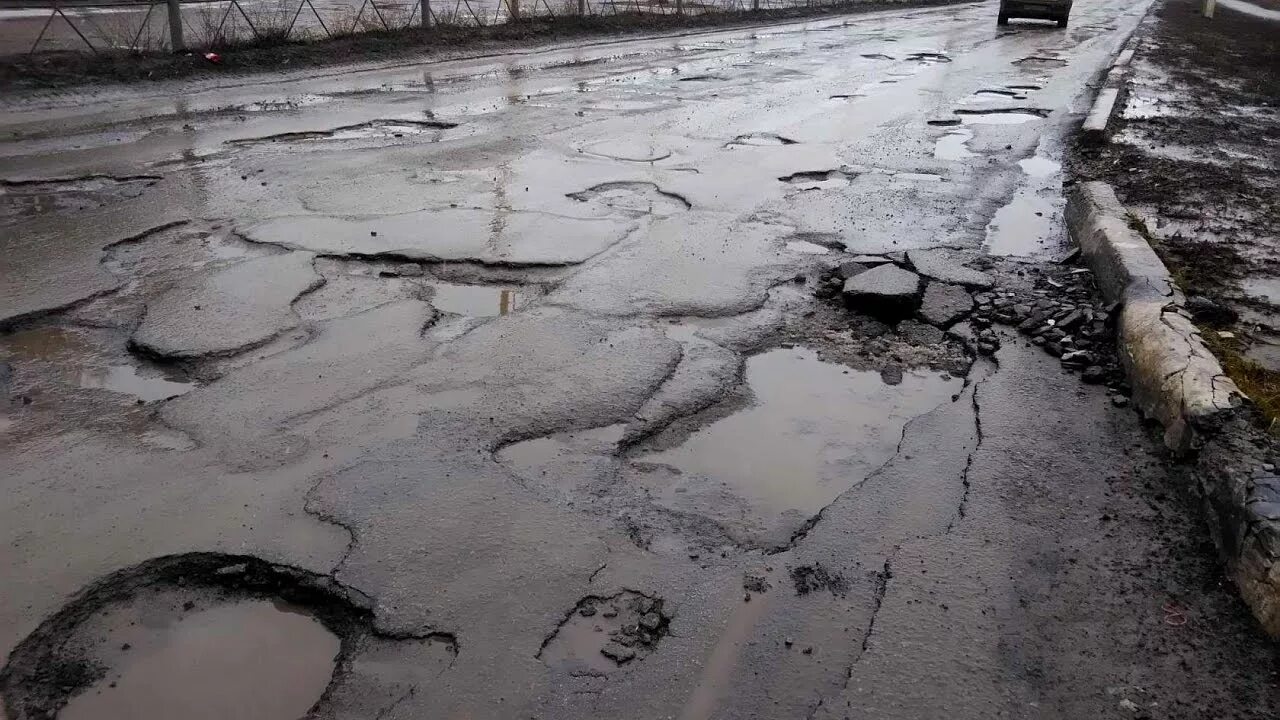 Снег весной на дороге. Асфальт растаял. Ямы город дорога. Асфальт растаял вместе со снегом. Огромная яма на дороге.