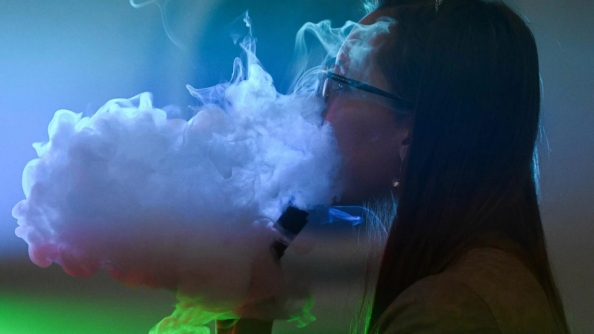 Девушка с вейпом. Выдыхает дым. Дым помогает. Дым от сигарет. Человек в дыму.