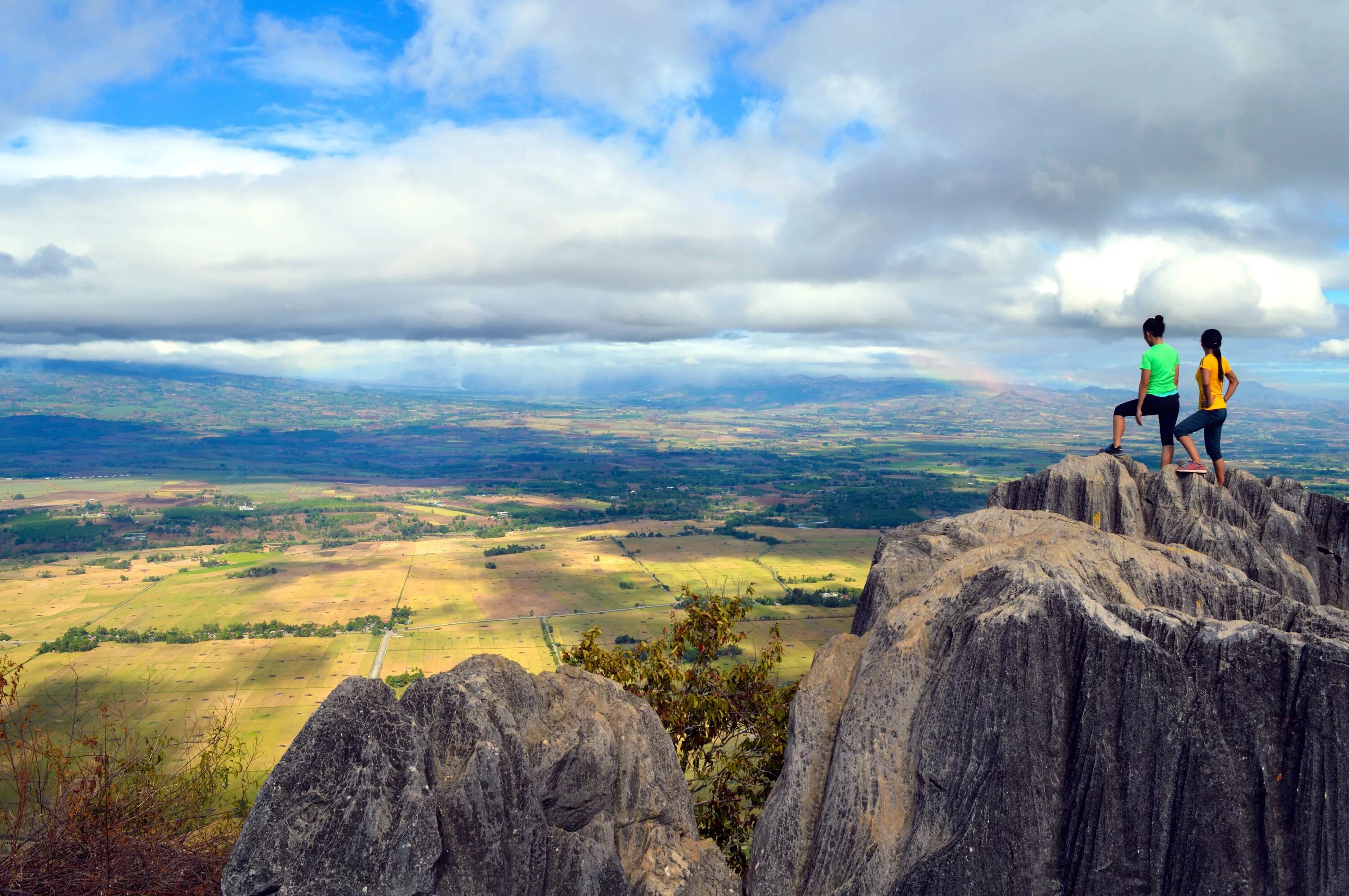 Вершина. Горы вдалеке. Человек на обрыве скалы. Человек на вершине скалы. Стоить гора.