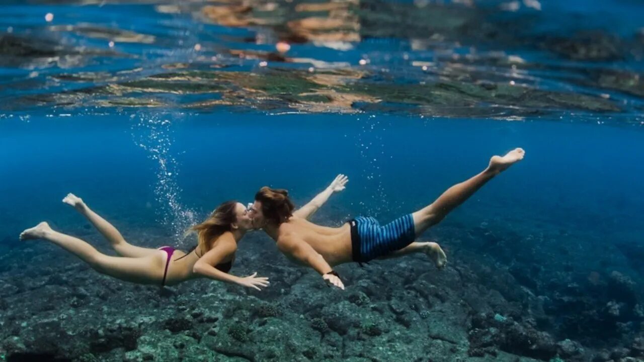 Под водой. Девушка плавает в море. Девушка плывет в море. Фотосессия под водой.