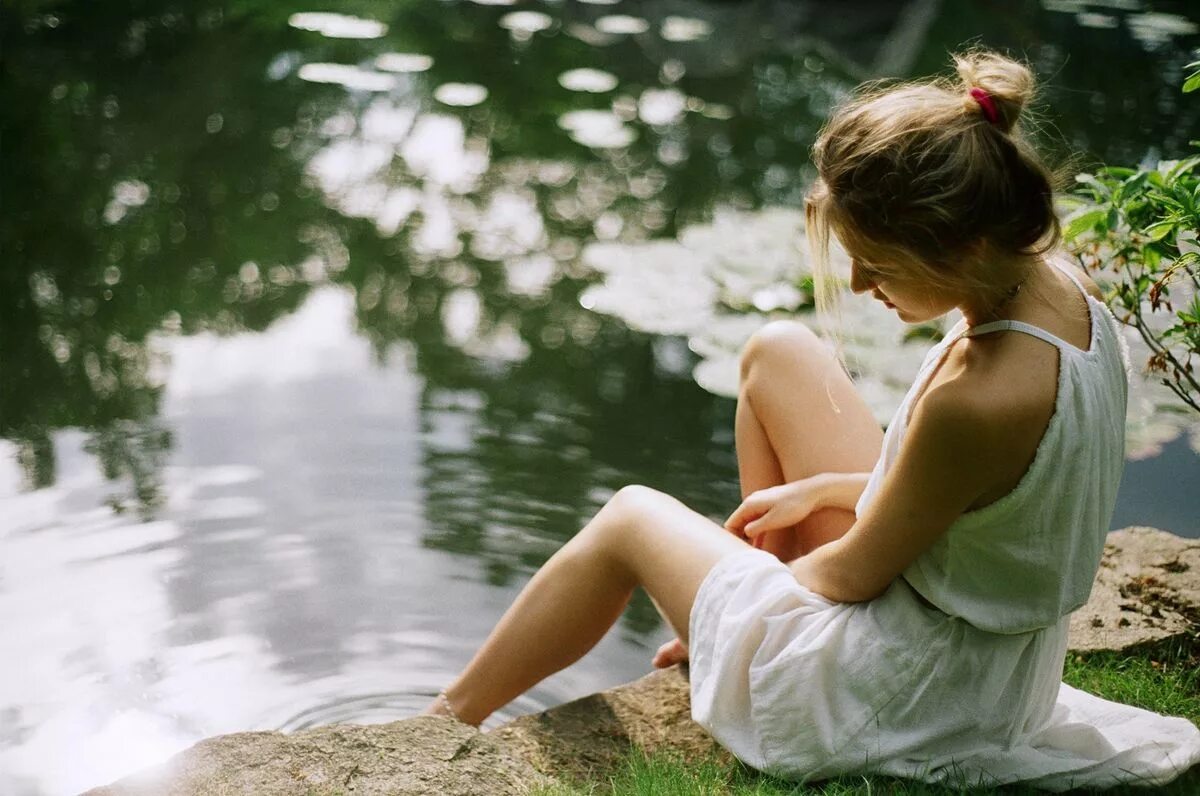 Красоту сидели люди. Девушка сидит на берегу. Девушка сидит у воды. Девушка сидит спиной. Девочка в платье сидит спиной.