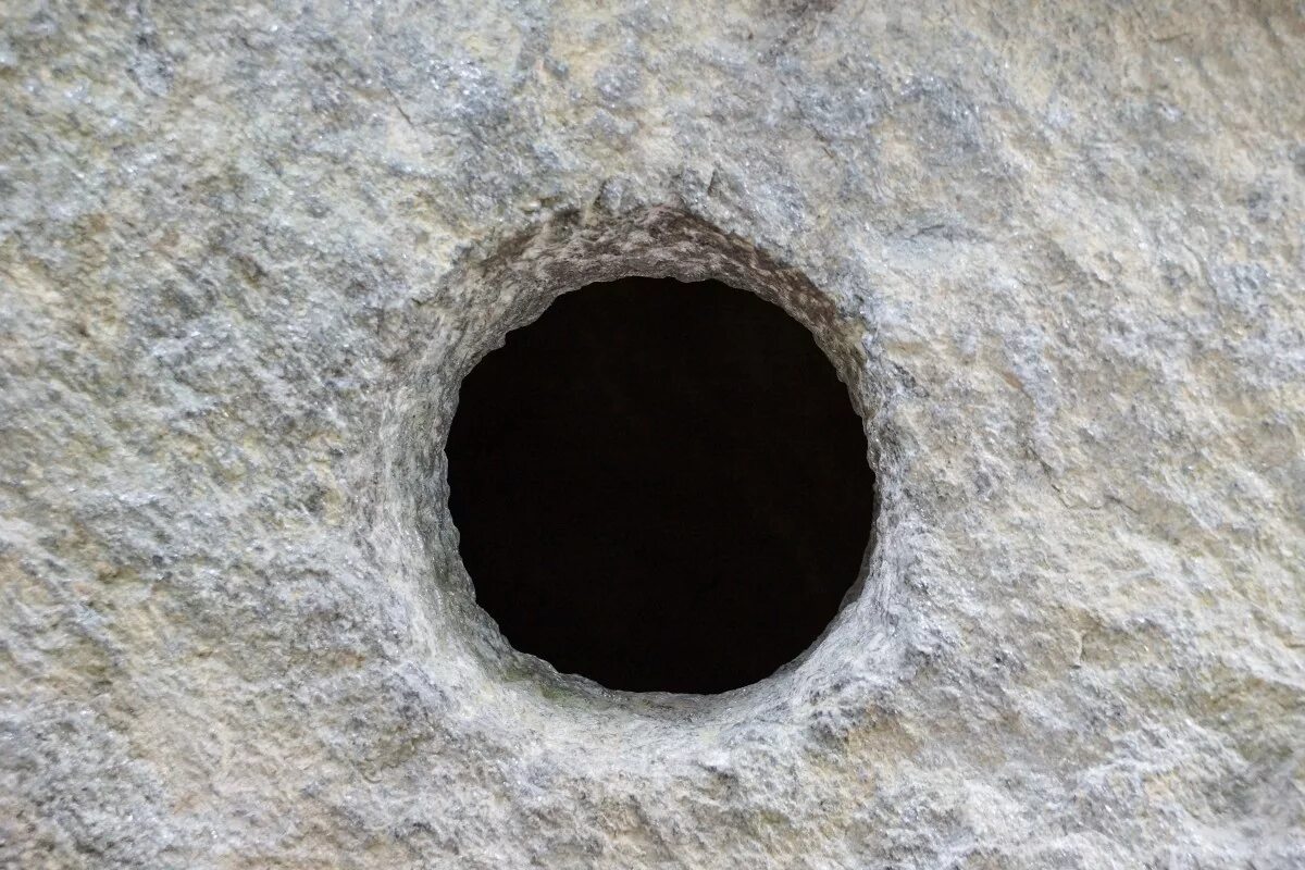 В стене дыра в дыре глаза. Дыра в скале. Отверстие в скале. Круглая дырка. Глубокая дыра.