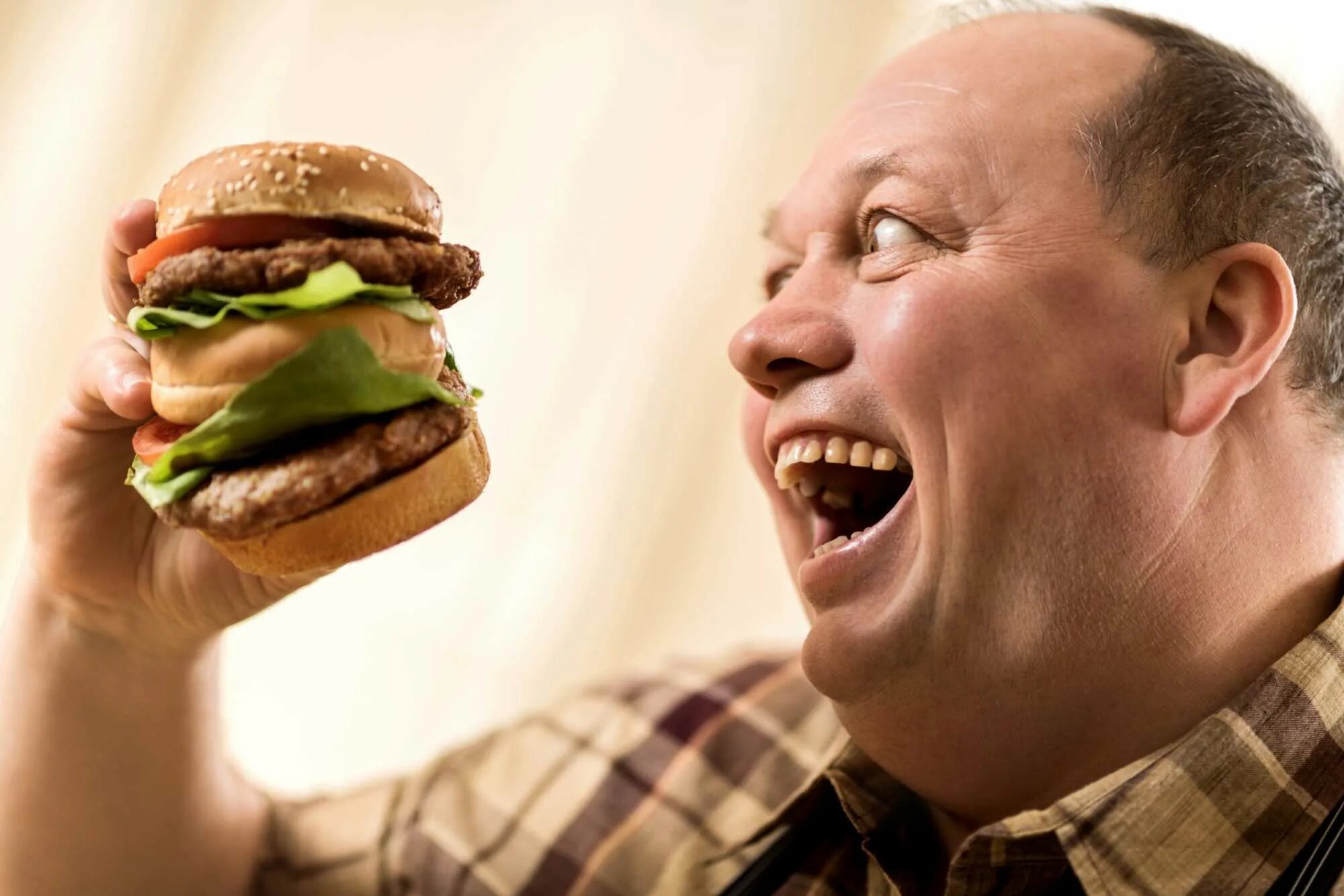 Ешь и толстым становишься. Человек ест бургер. Человек гамбургер. Человек ест гамбургер. Человек с едой.