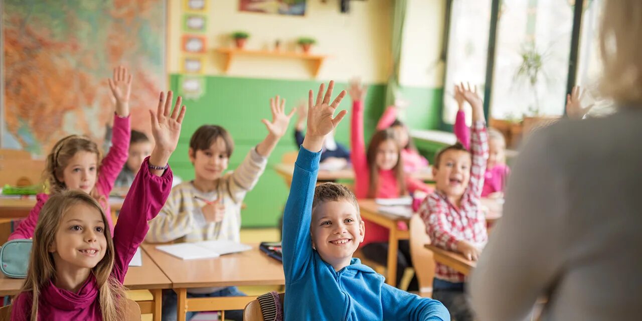 ученик сидит за партой. дети в школе за партой. дети в классе поднимают руки. ученик. поднять руку на уроке.