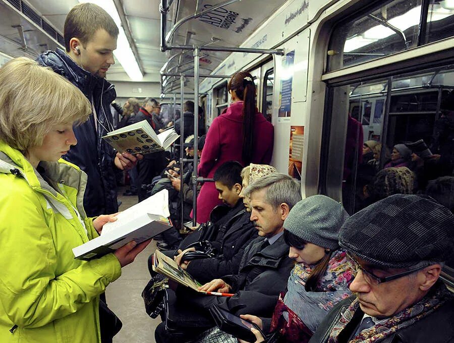 Чтение в транспорте. Чтение в метро. Люди читают в метро. Люди в метро. Она читает в метро
