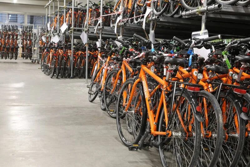 На складе велосипедов среди них женских. Склад велосипедов. Вело склад.ру. Фото велосипедного склада. Фото велосипед оранжевый в гараже.