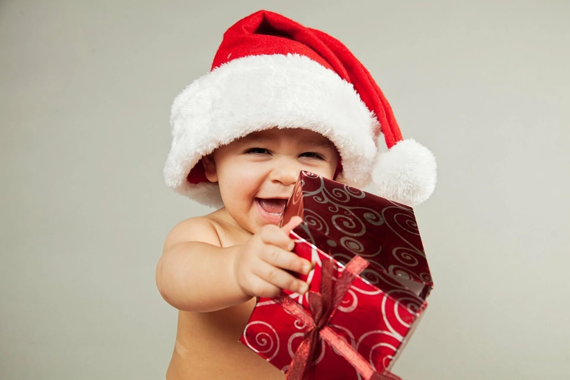 Малыши дед мороз. Новогодние подарки для детей. Малыш в новогодней шапке. Под для детей. Санта и дети.
