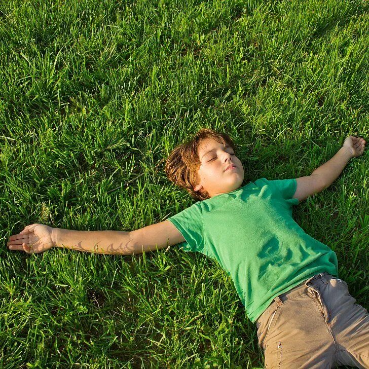 Мальчик лежит на траве. Мальчик лежит. Мальчик на траве. Мальчик лежит на лужайке.