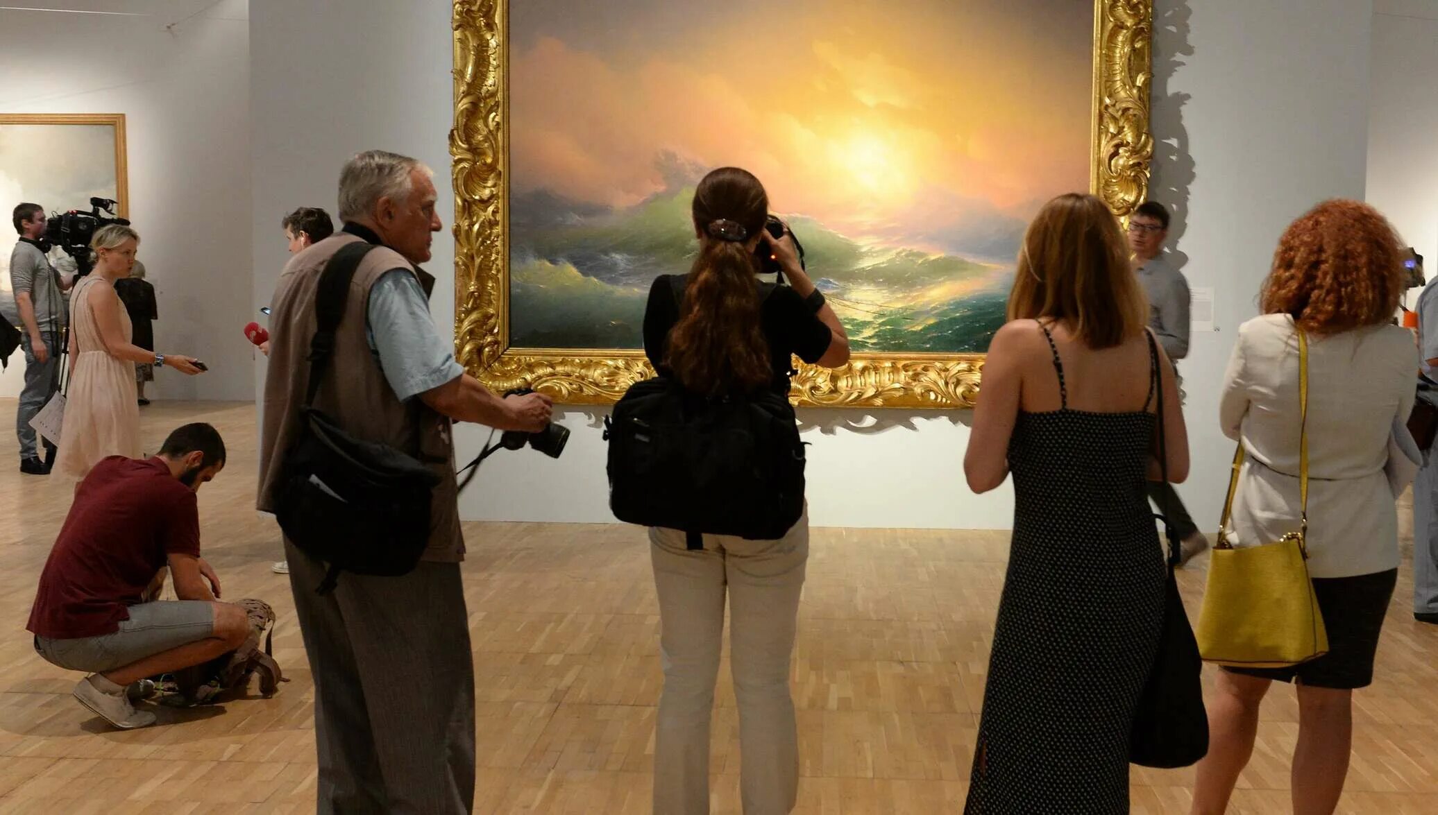 Картина обсуждение. Выставка Айвазовского в Третьяковке. Люди в галерее. Посетители картинной галереи. Люди в галерее смотрят на картину.
