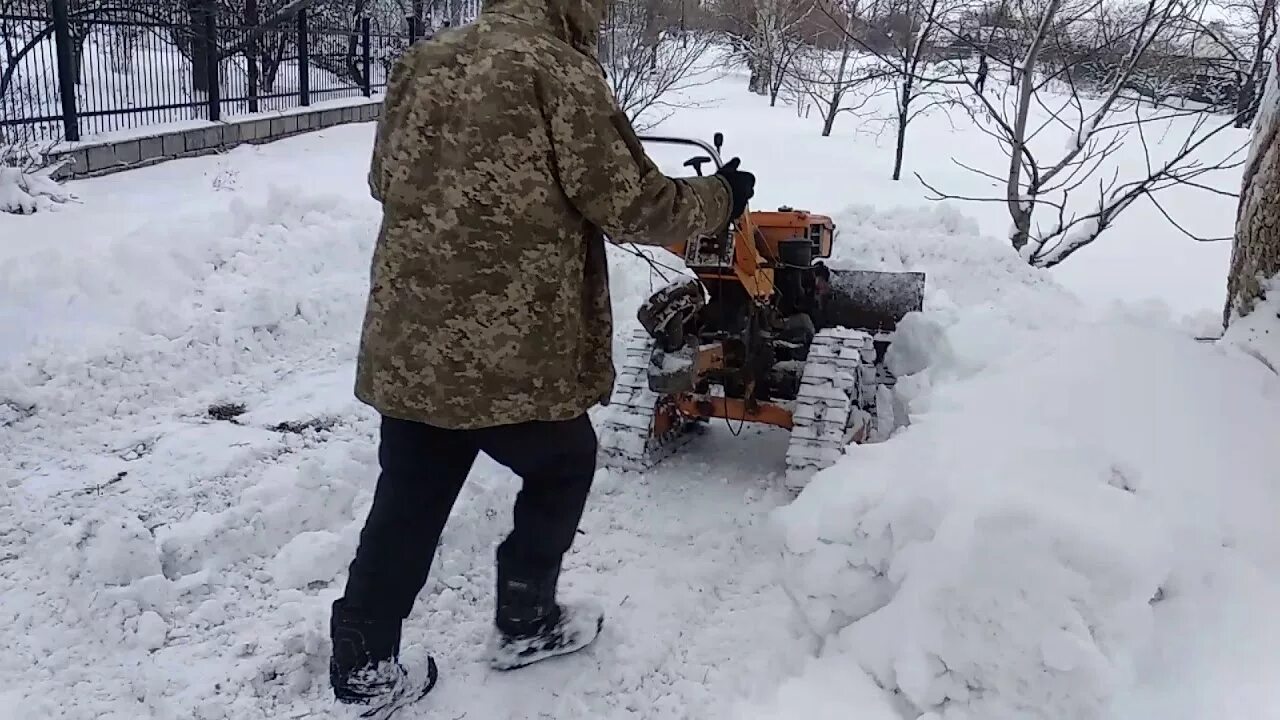 Уборка снега мотоблоком купить. Мотоблок МТЗ чистка снега. Мотоблок на гусеницах для чистки снега. Мотоблок убирает снег. Уборка снега мотоблоком с отвалом.