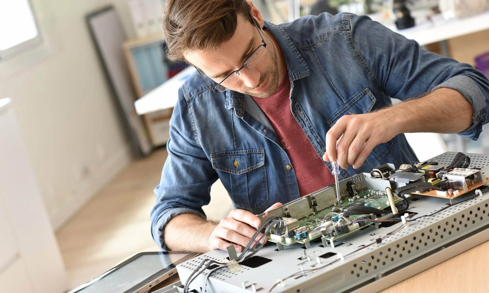 Человек ремонтирует телевизор. Мастер чинит телевизор. Мастер телевизоров. Чинит телевизор. Мастер по ремонту телевизоров.
