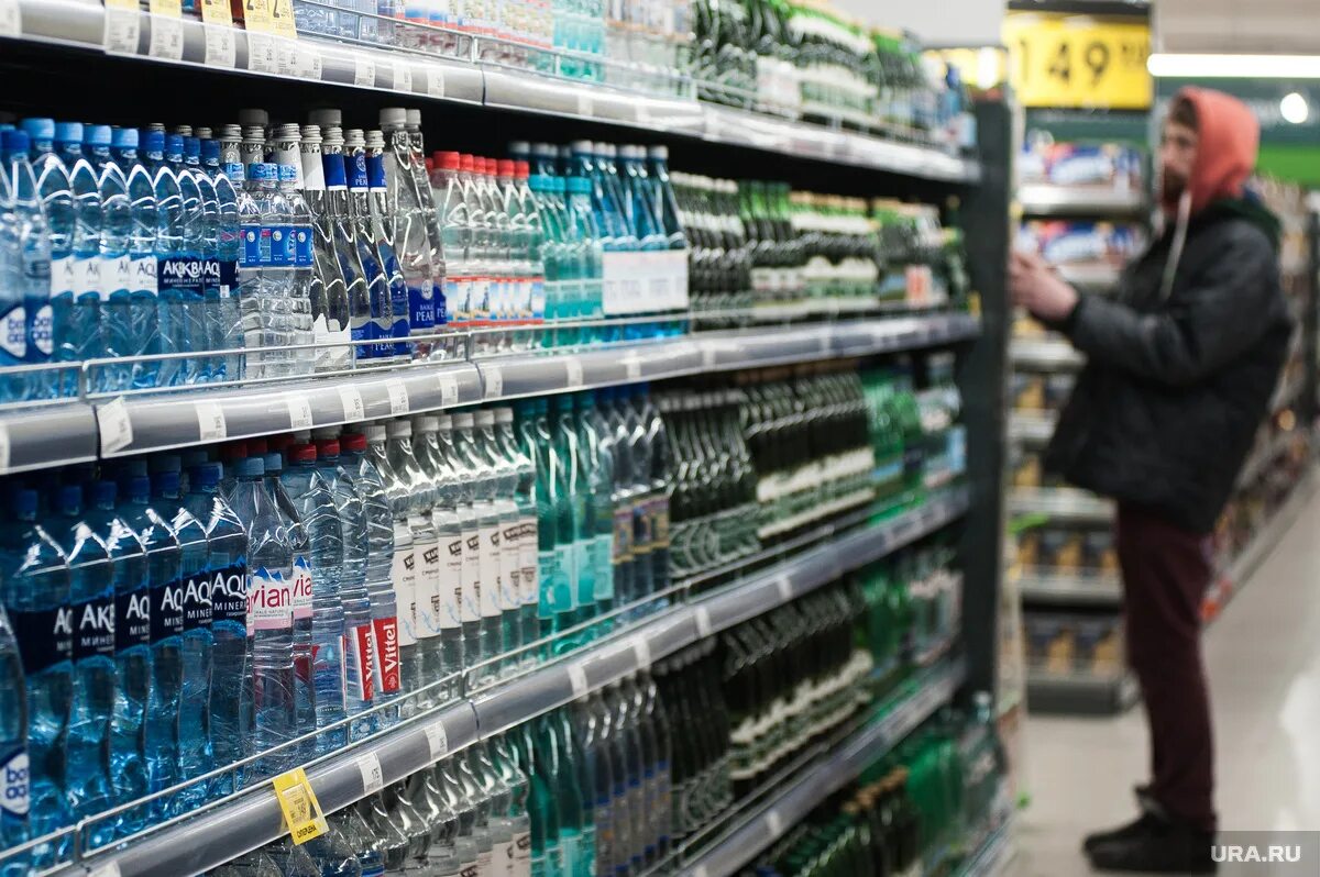 ассортимент минеральной воды в магазине. витрина с водой. троллей супермаркет. выкладка минеральной воды. вода в магазине.