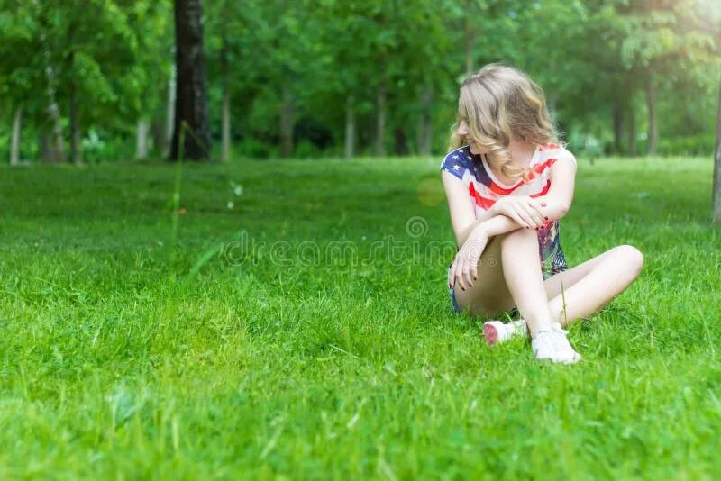 Tween sitting on grass. Фото девочки блондинки 4 х или 5 лет на травке. Tween playing in the grass. Дочка присела на травке домашнее фото.