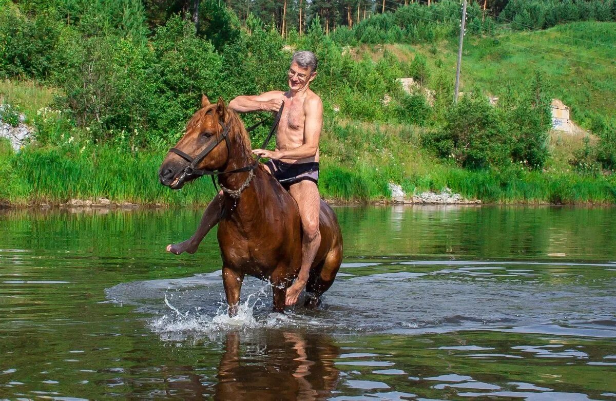 Купание коня. Мальчик купание коней. Лошади купаются в реке. Мужчина купает лошадь. Купание лошадей