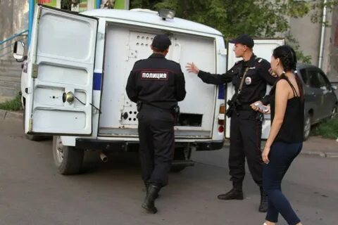 Полицейский обыскивает девушку