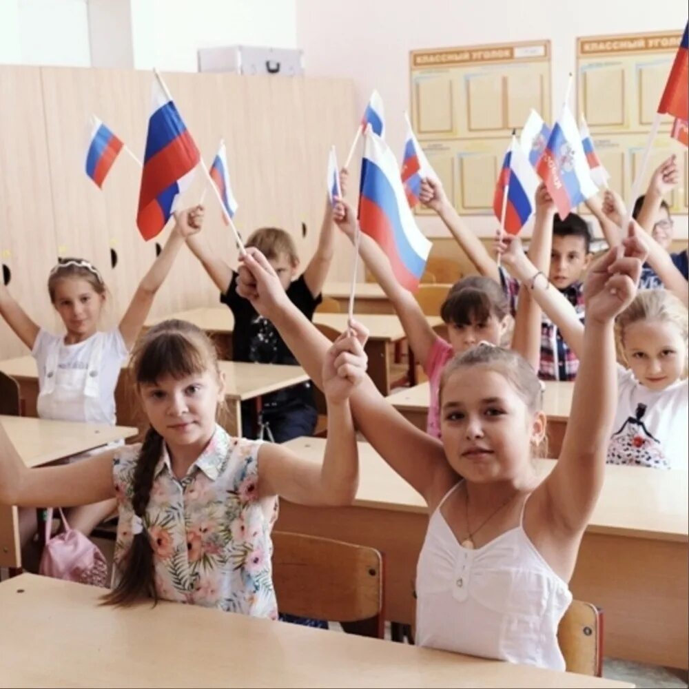Школьники в школе с российским флагом. Урок патриотизма в школе. Школа с российским флагом. Российские школьники с флажками.