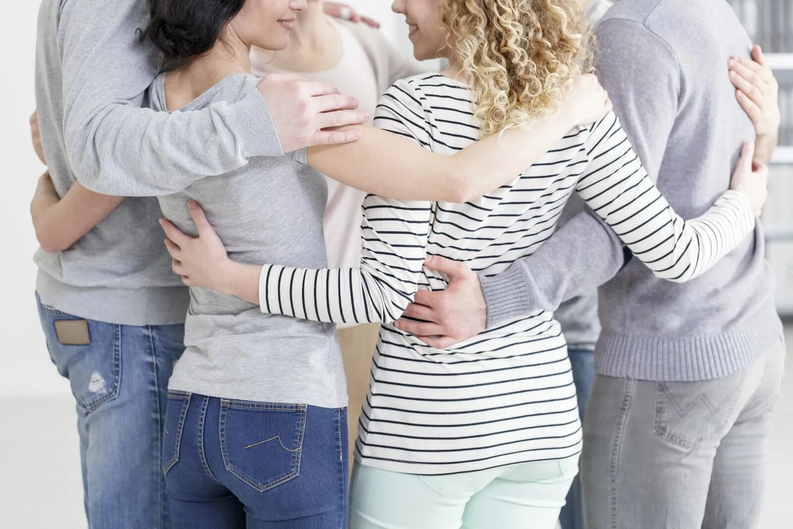 объятия в свитерах. обнимашки людей. парень и девушка держатся за руки. подруги со спины. два парня смеются.