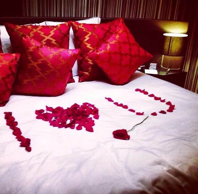 Романтичная постель. Лепестки роз на постели. Лепестки роз на кровати. Романтический вечер. Романтическое украшение спальни.