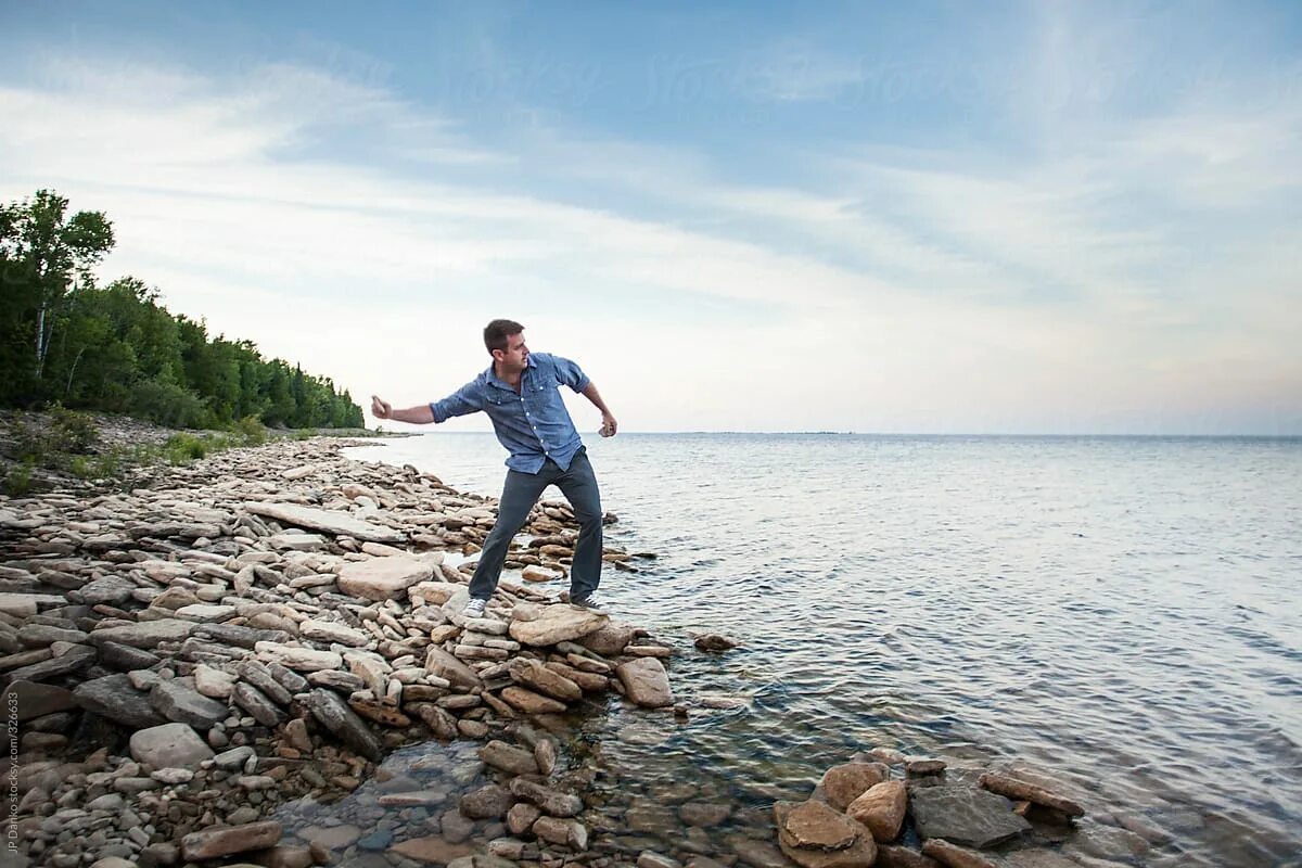 Skipping stones. Стоун-скиппинг. Стоунскиппинг спорт. Камешек прыгает по воде. Камень прыгает по воде горизонтальное фото.