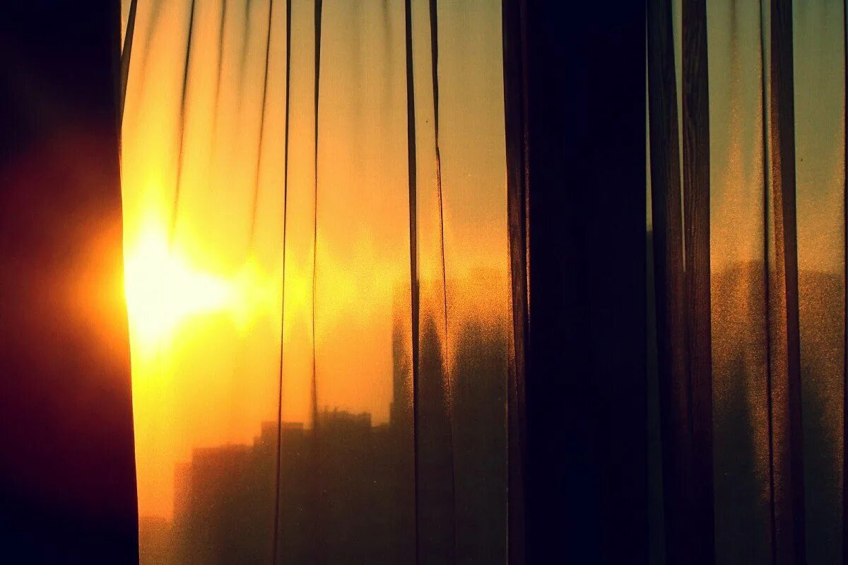 Яркое солнце светит в окна домов. Лучи солнца в комнате. Солнце сквозь шторы. Луч солнца в окне. Лучи солнца через окно.