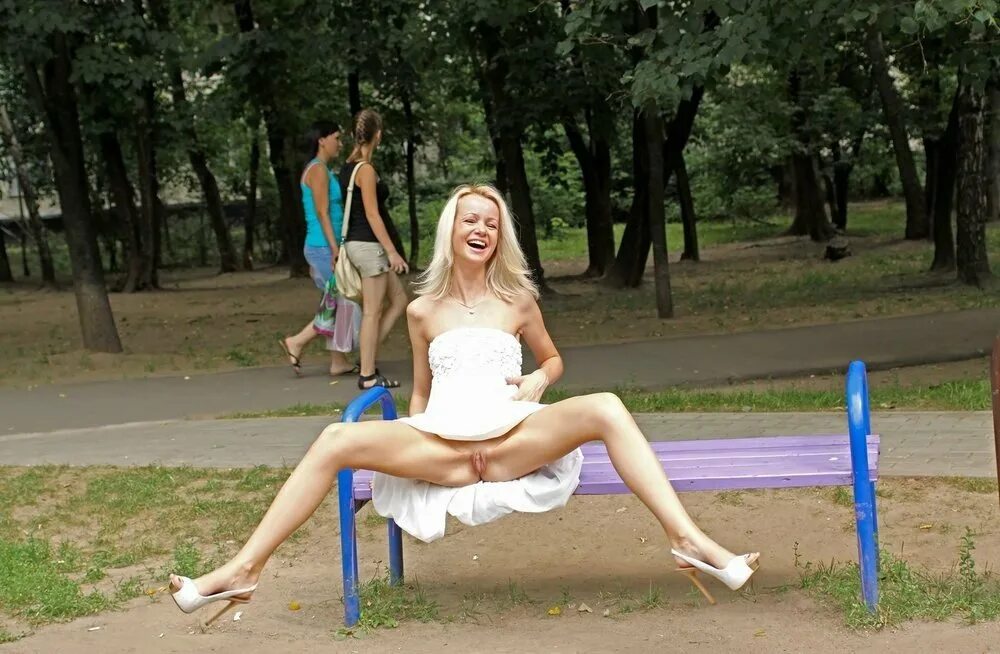 В публичных местах длинноволосая блондинка показывает сиськи и бритую киску 