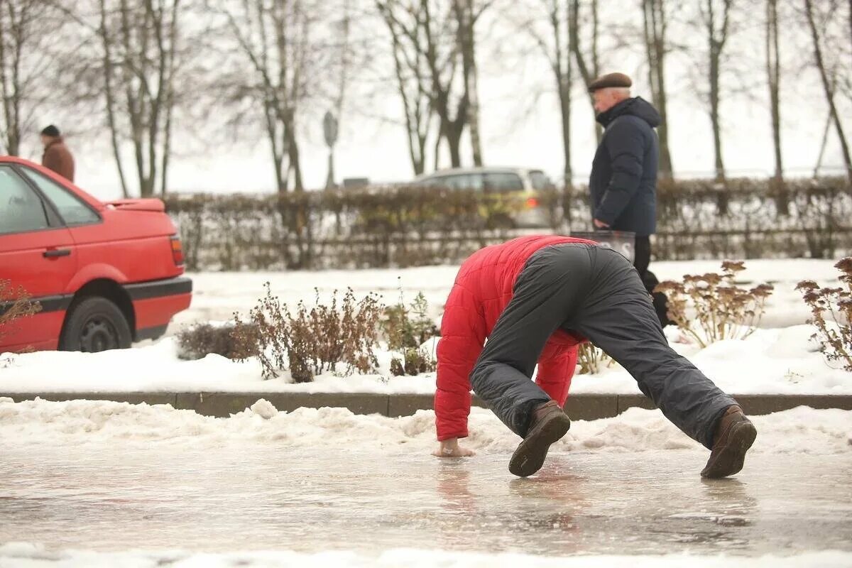 На улице очень скользко. Гололед на улице. Человек подскальзывается на льду. Гололед в городе. Очень скользко на улице будьте осторожны.