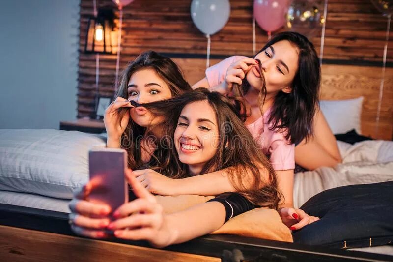 Двое читают листок. Улыбающийся человек. Парень и девушка делают селфи. Красивые люди группа. Семья сидит на паркете.