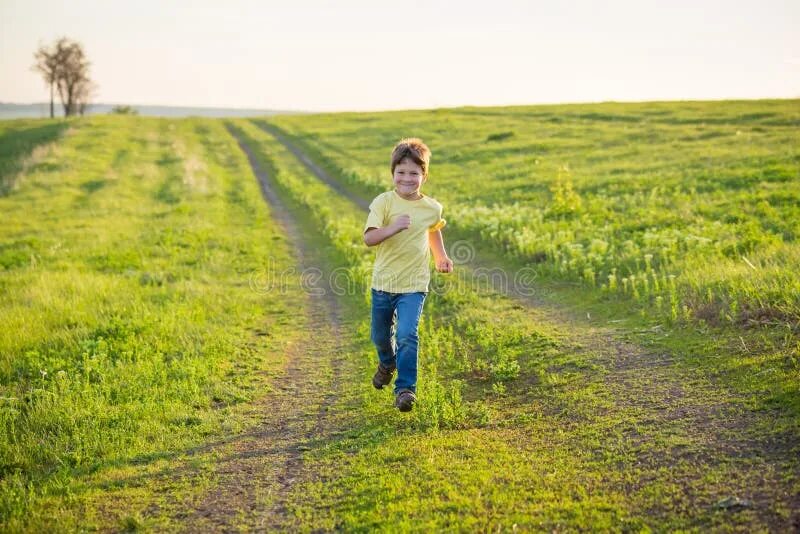 Мальчик бежит по дороге. Мальчик босиком в поле. Мальчик бежит по полю. Радостный мальчик на зеленом поле. Бежит и бежит дорога бежит навстречу солнцу