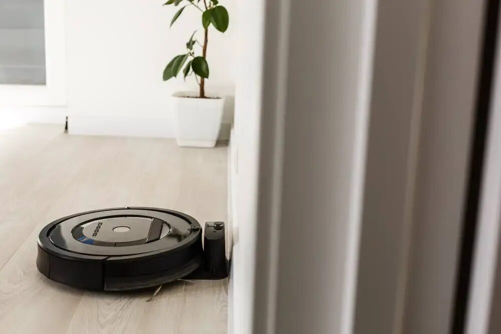 Отключать ли робот пылесос от сети. Зарядка для робота пылесоса. robot vacuum cleaner in room. робот пылесос заряжается фото.