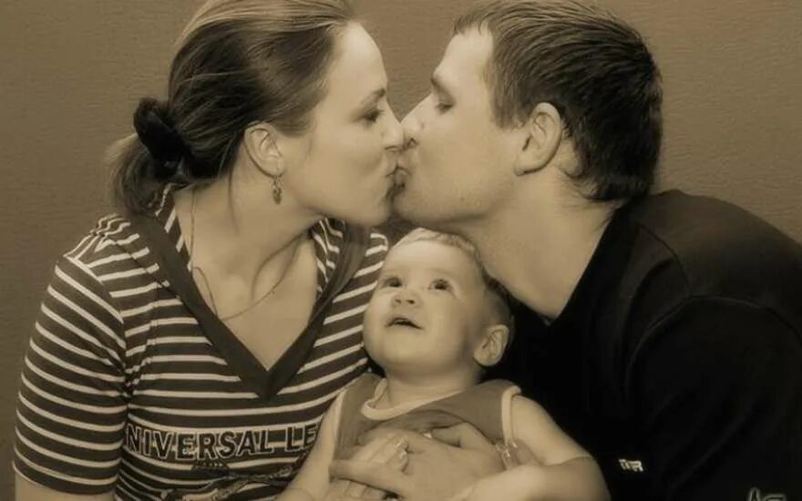 Мама и папа целуют малыша. Поцелуй родителей. Папа целует маму. Мама и папа целуются.