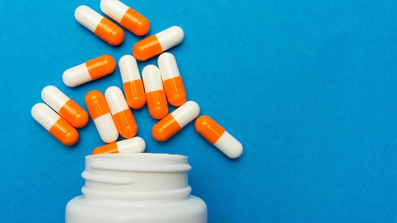 Капсулы бело-оранжевые. Антибиотики. Антибиотики фото. Антибиотики в таблетках. Благодаря антибиотикам многие