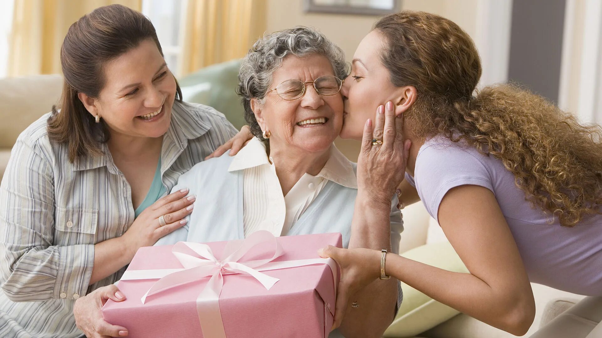 Подарок бабушке. Бабушка дарит подарок. Подарок пожилой женщине. Женщина дарит подарок матери. Бабушка и дочка и сын