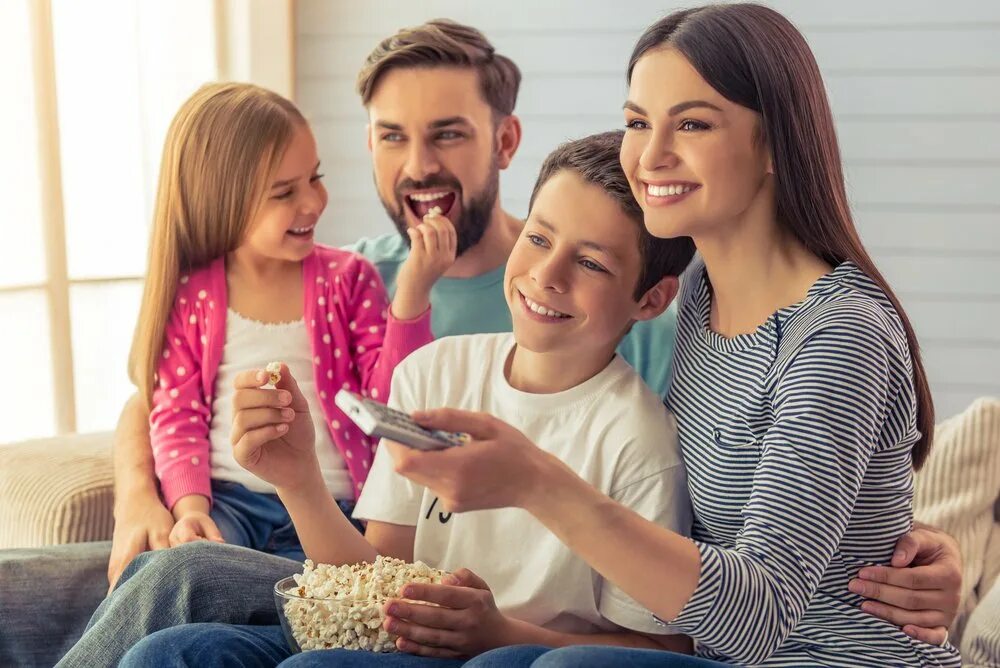 Young parent. Семья с попкорном. Счастливая семья у телевизора.